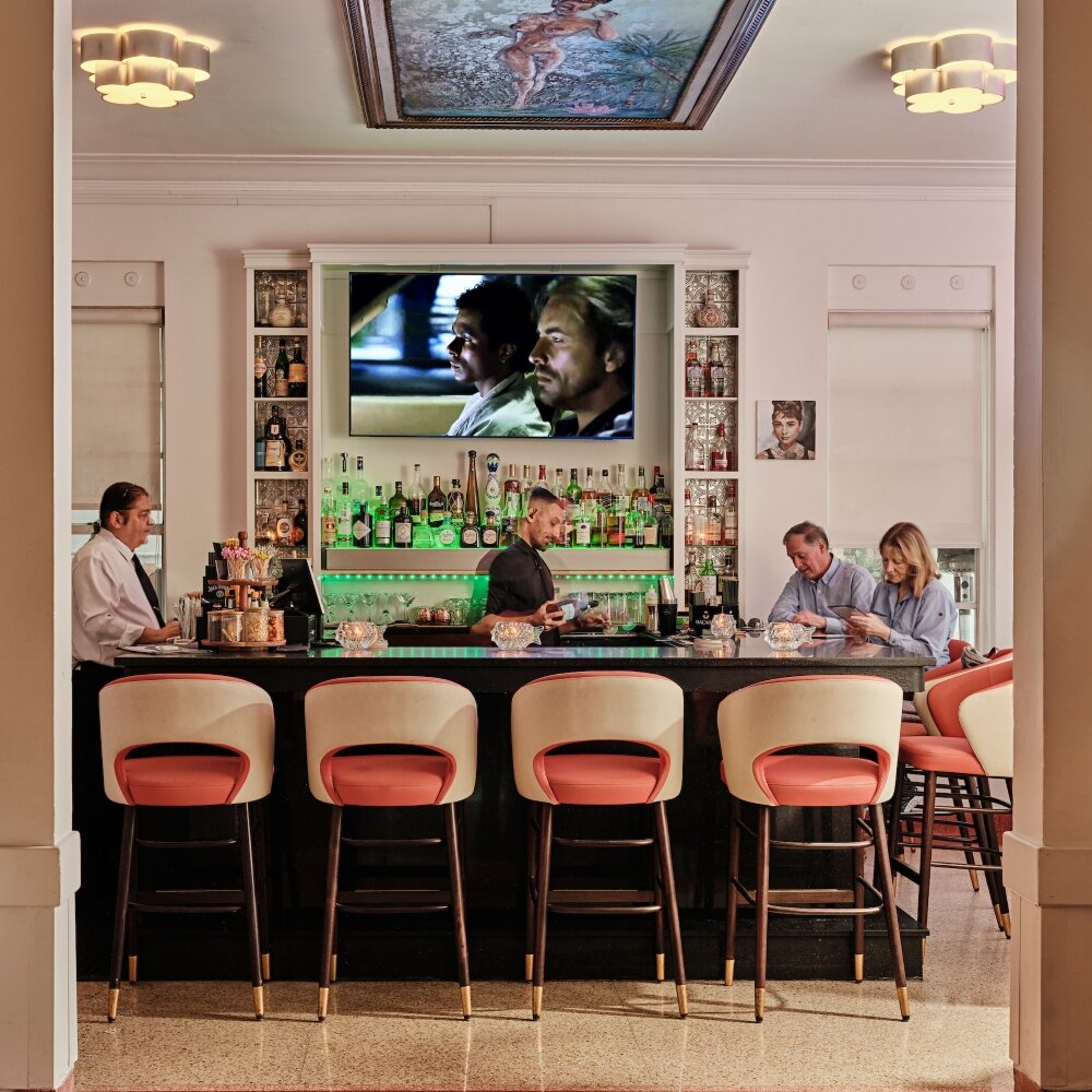 a wide view of a bar with a bartender and customers